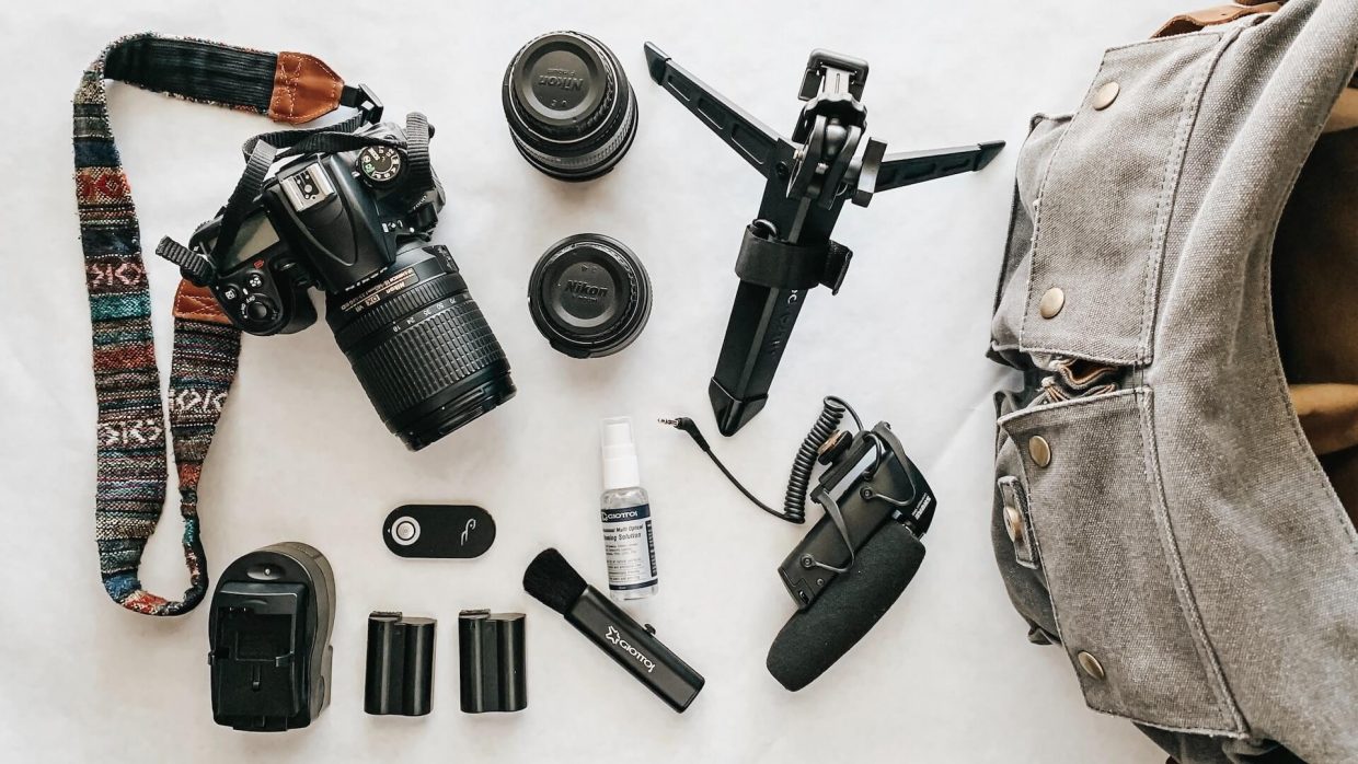 Image représentant un appareil photo accompagné de divers accessoires de photographie.