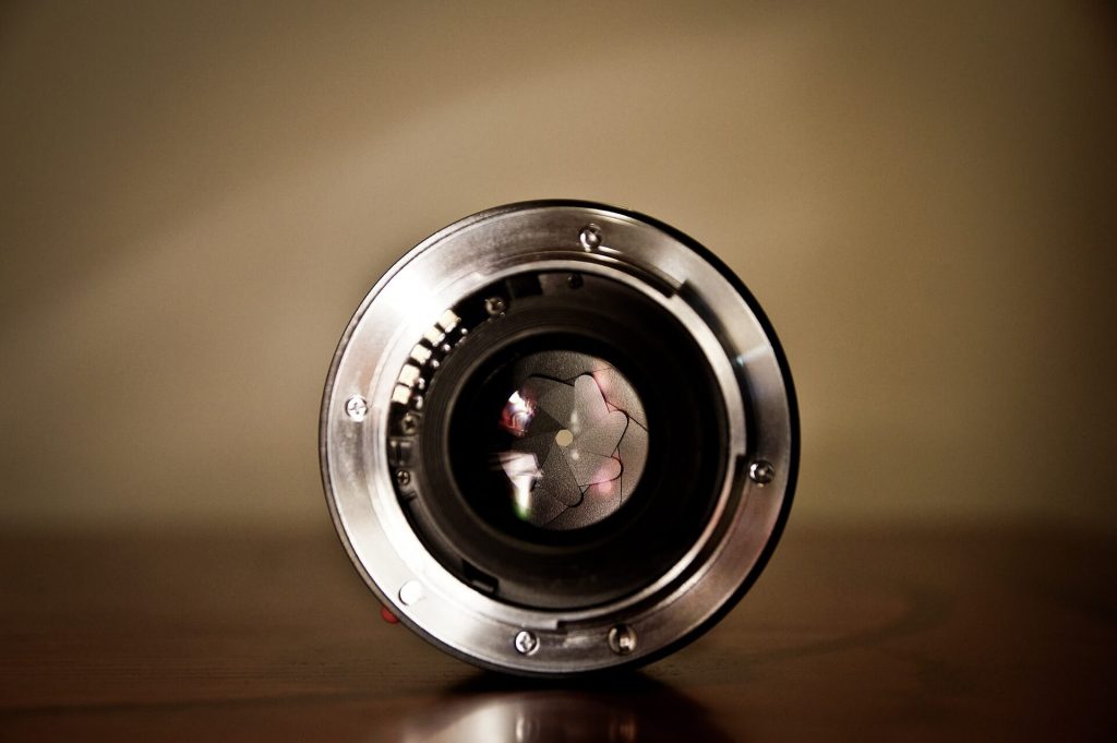 Image représentant la vue détaillée de l'objectif d'un appareil photo, avec son optique complexe et ses composants mécaniques, représentant l'outil essentiel pour la photographie et la capture d'instants.