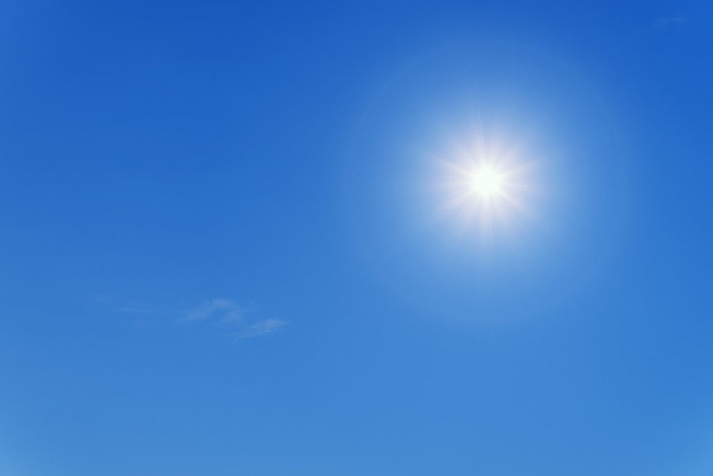 Image d'un soleil radieux qui brille dans un ciel bleu clair, illuminant les environs de sa lumière chaude et vivifiante.